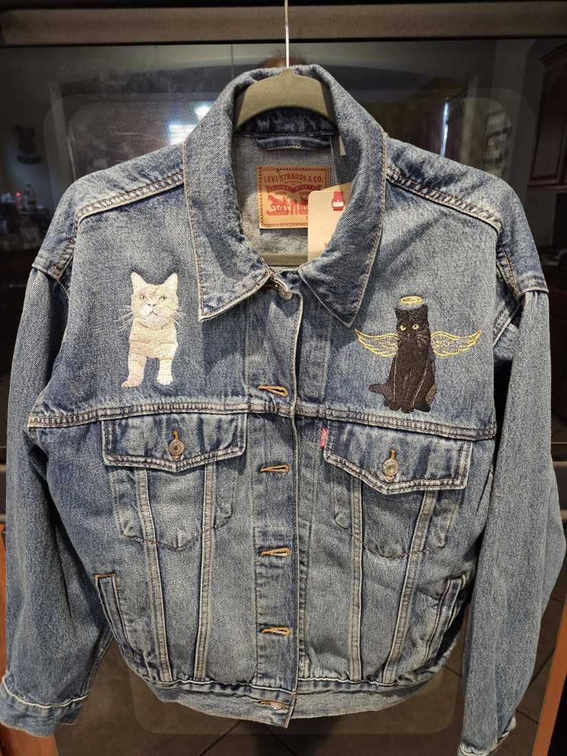 Denim jacket with an embroidered tabby cat and a black angel cat on the chest